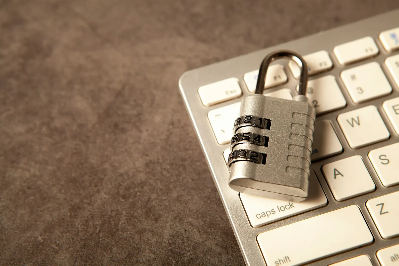 Combination padlock resting on a laptop keyboard